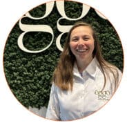 Une personne en chemise blanche se tient devant un mur de mousse verte avec le logo "èggo" en lettres blanches.